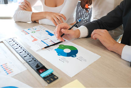 Business people discussing the charts and graphs showing the results of their successful teamwork, multi ethnic business