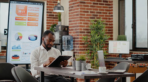 African american man greeting team of coworkers in startup office, meeting to plan project and work on business strategy. Group of colleagues preparing to design financial presentation.