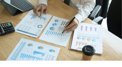 The management is checking the accuracy of the company budget information.He uses the pen point to graph on the desk in office.