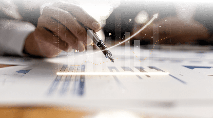 Two businessmen are meeting together, they point to financial documents to discuss plans and solutions, chart graphics showing financial status and performance. Business administration concept.